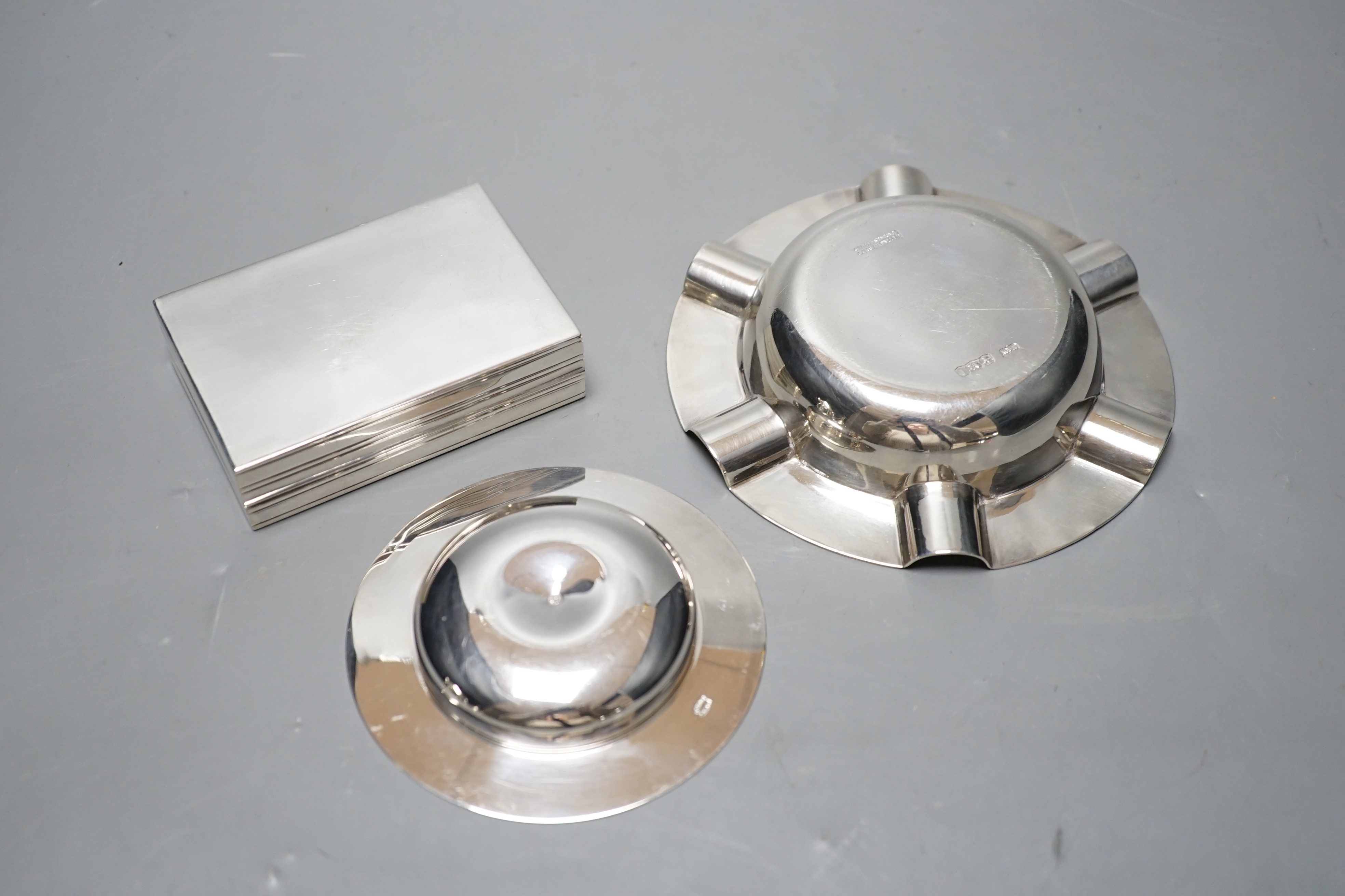 A George V silver ashtray, Mappin & Webb, Sheffield, 1928, 13cm, a modern Asprey & Co small dish and a continental white metal box and cover, gross 12.2oz.